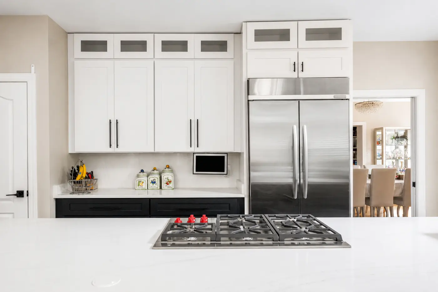Remodeled kitchen with white shaker cabinets, a quartz counter and a stainless refrigerator